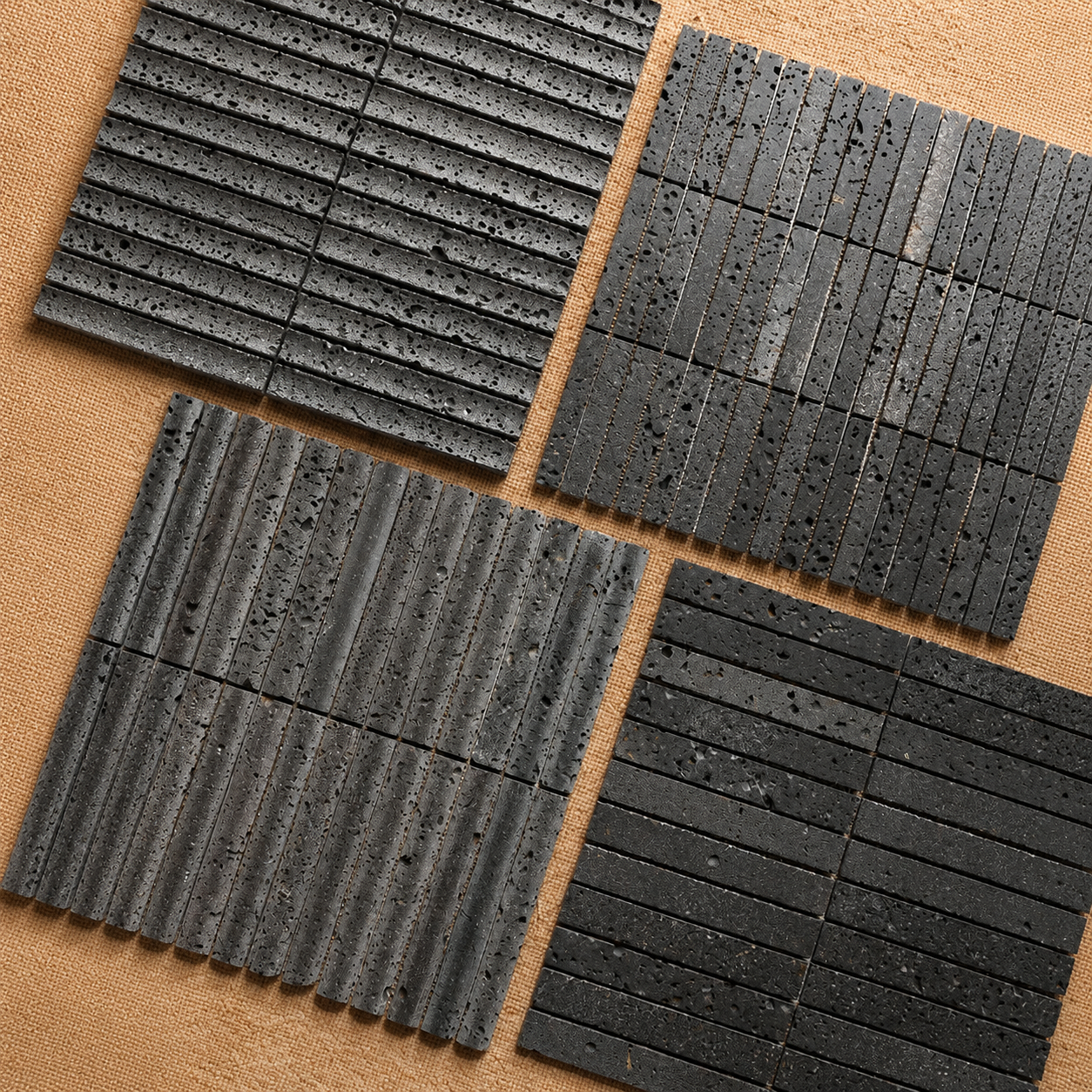 Black lava stone strip mosaic tile texture close-up - natural volcanic pores